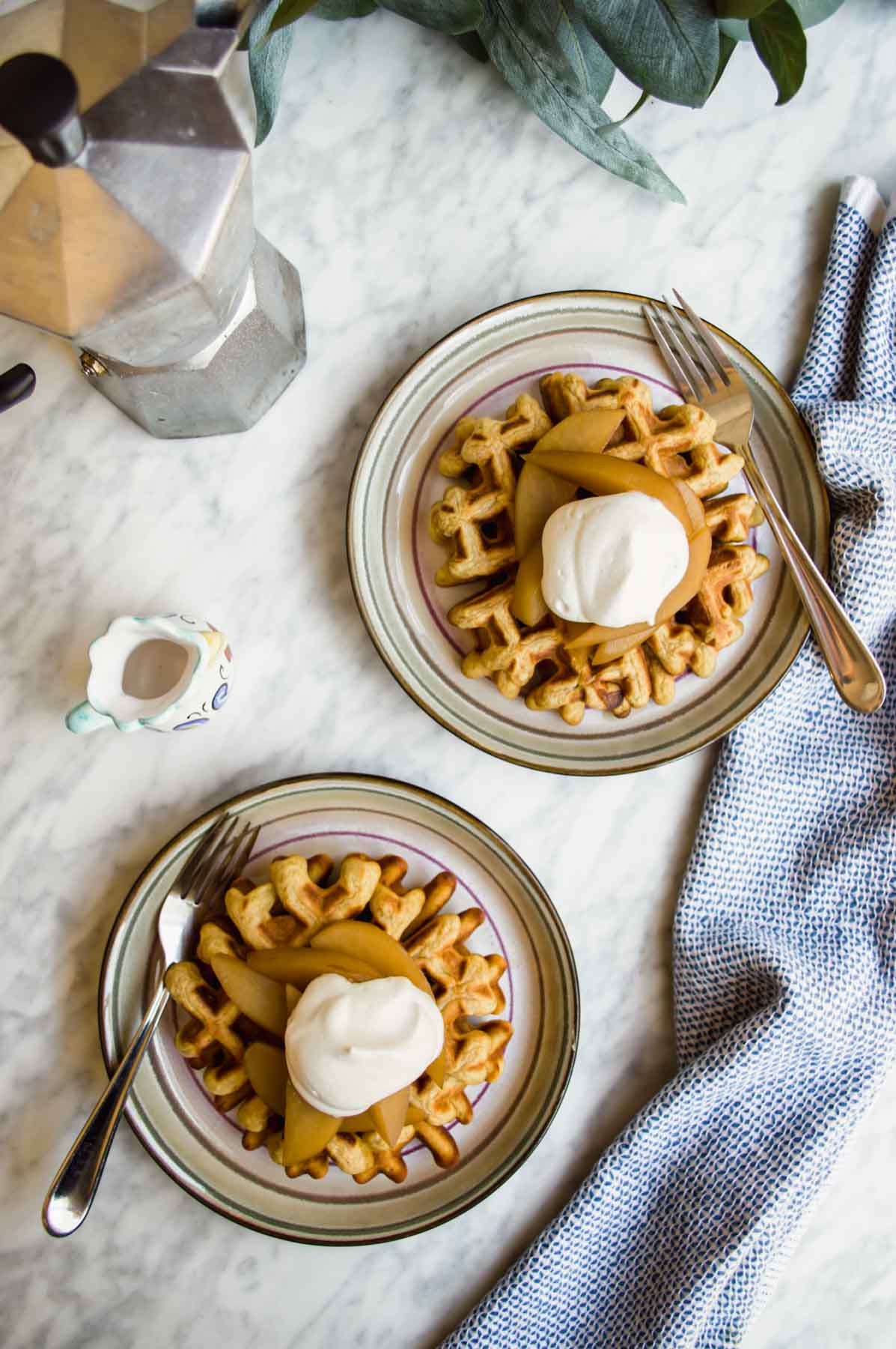 Belgian Waffles with Cinnamon Poached Pears on plates with espresso flatlay.