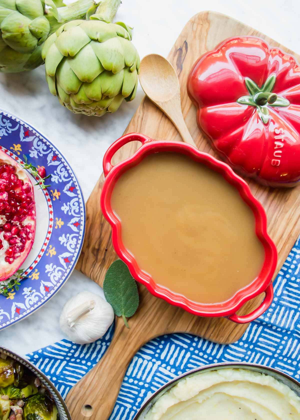 Classic Gravy in tureen with other thanksgiving sides flatlay.
