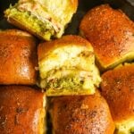 Hawaiian roll turkey pesto sliders with Swiss cheese and honey in a cast iron skillet.