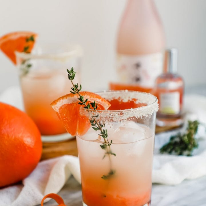 Grapefruit Honey Sake Cocktail in glasses and Skylar perfume.