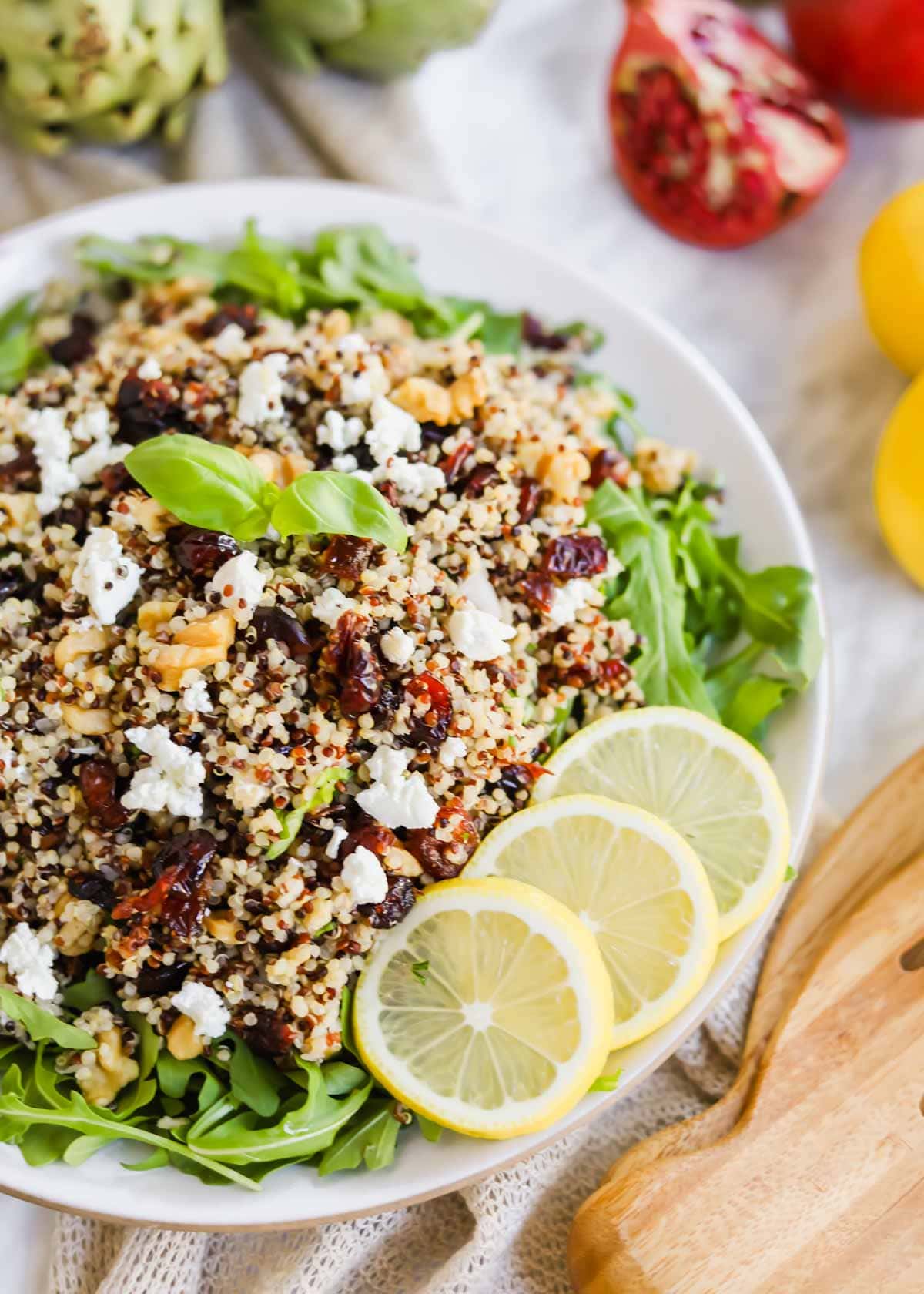Harvest Salad with Quinoa and Arugula and lemon slices on plate.