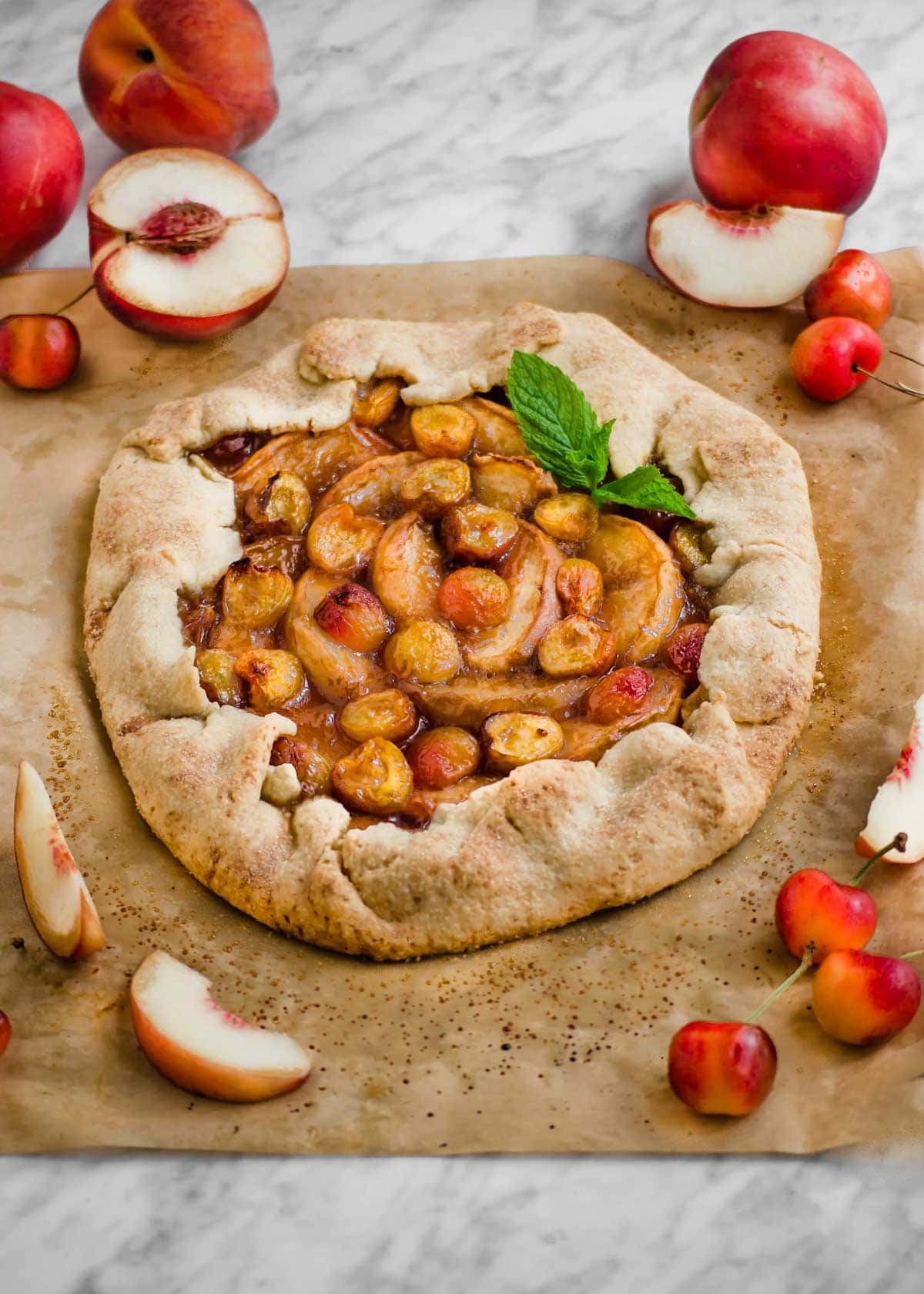 White Peach and Cherry Galette on parchment paper.