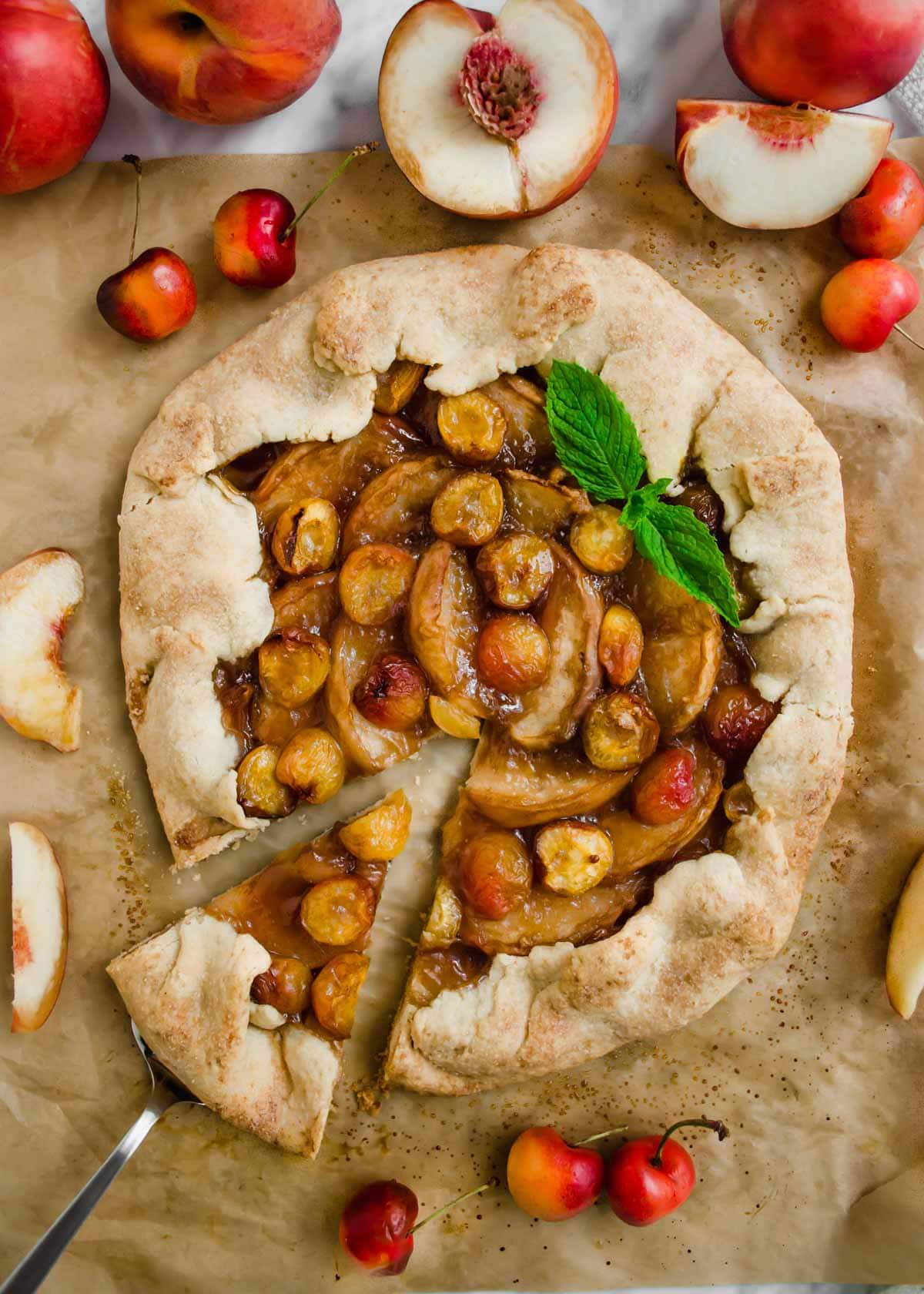 White Peach and Cherry Galette on parchment paper flatlay.