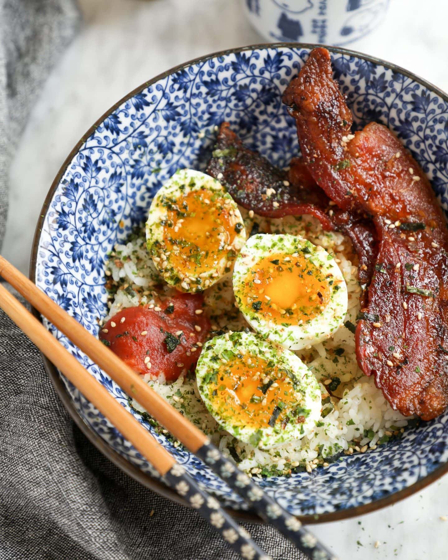 japanese breakfast egg and bacon bowl with chopsticks in a .