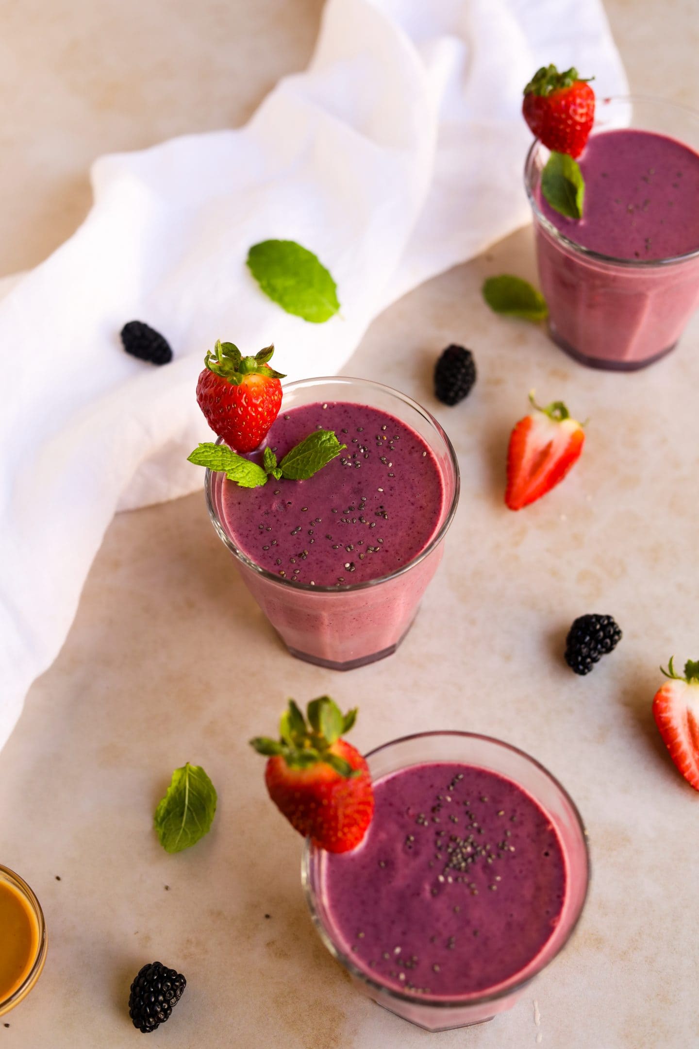 Peanut Butter and Berry Smoothie in glass Duralex cups with strawberries and mint