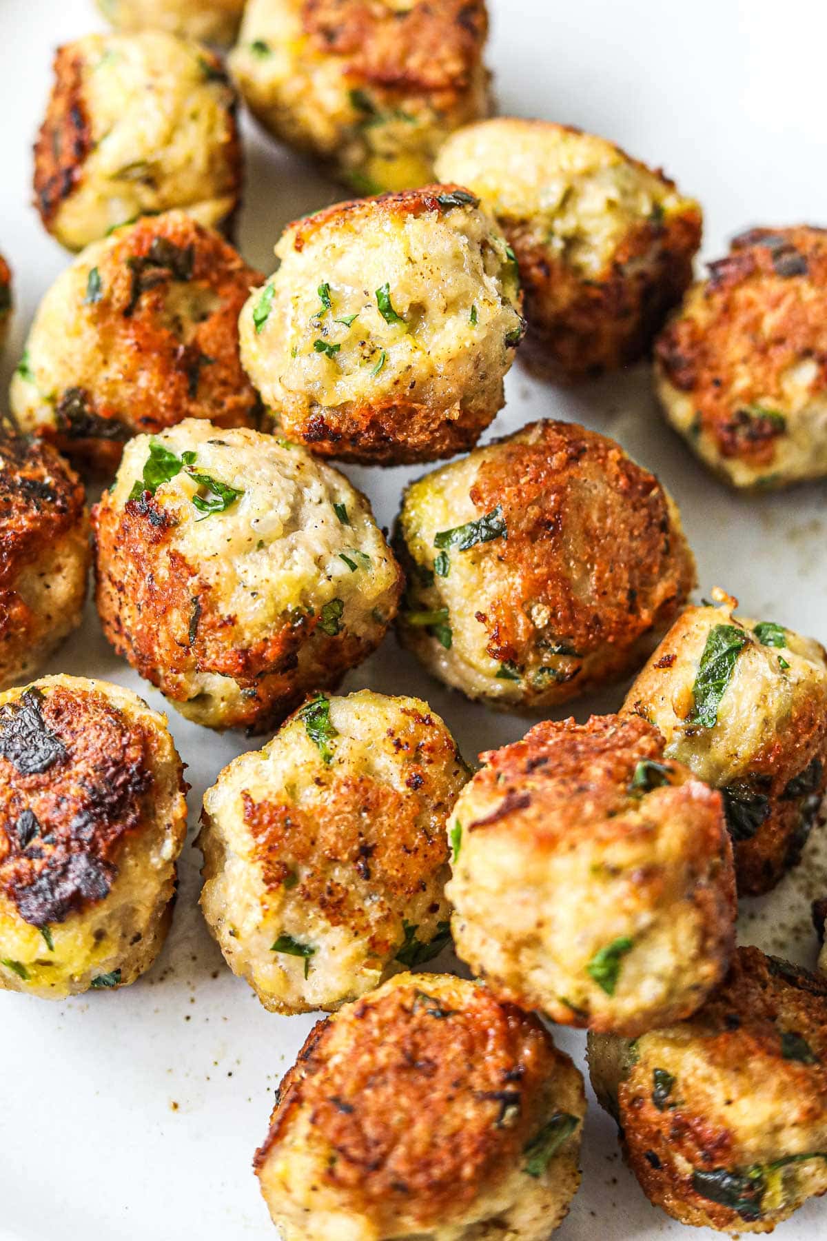 Baked or pan-friend healthy turkey meatballs in a pile on a plate.