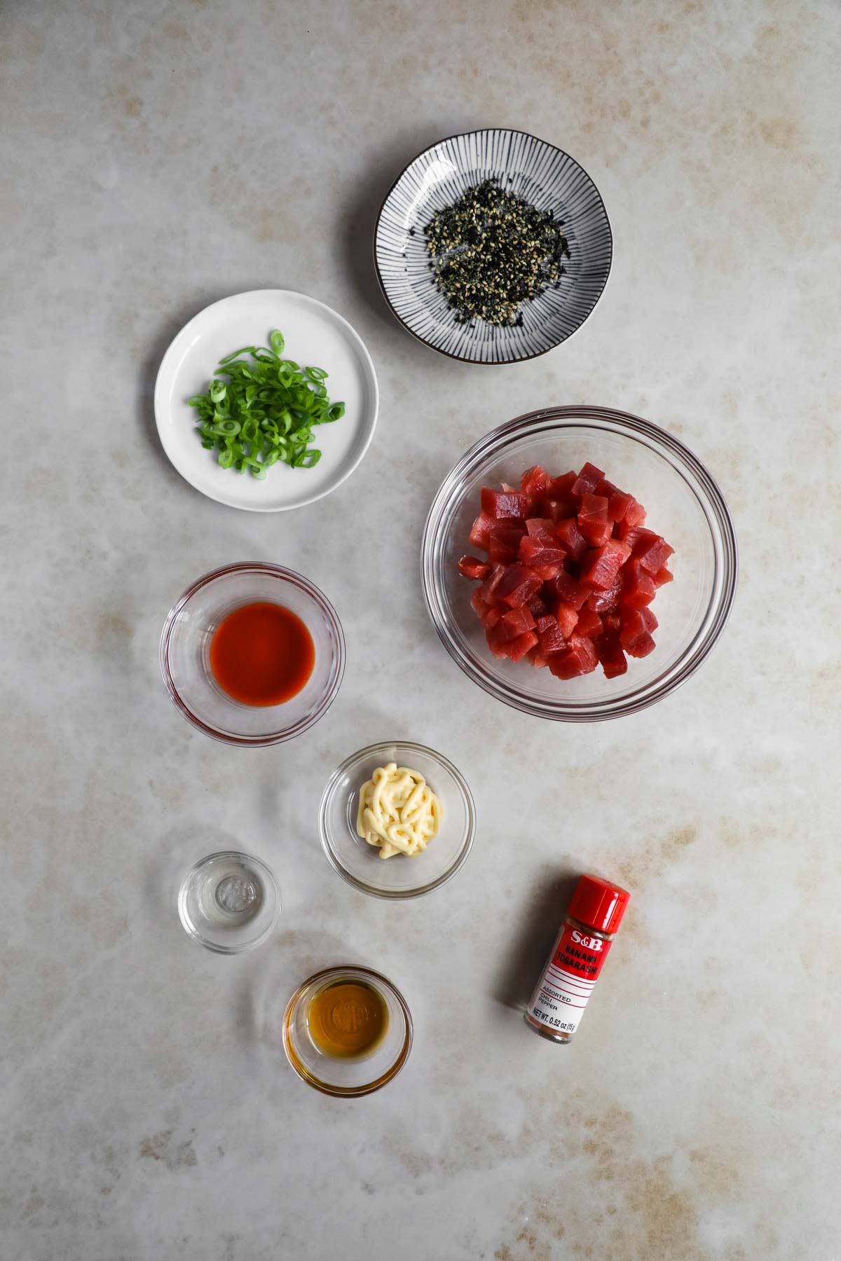 Spicy Ahi Poke Bowl Ingredients. Ahi tuna, furikake, scallions, togarashi, sesame oil, Sriracha, kewpie mayo, mirin.