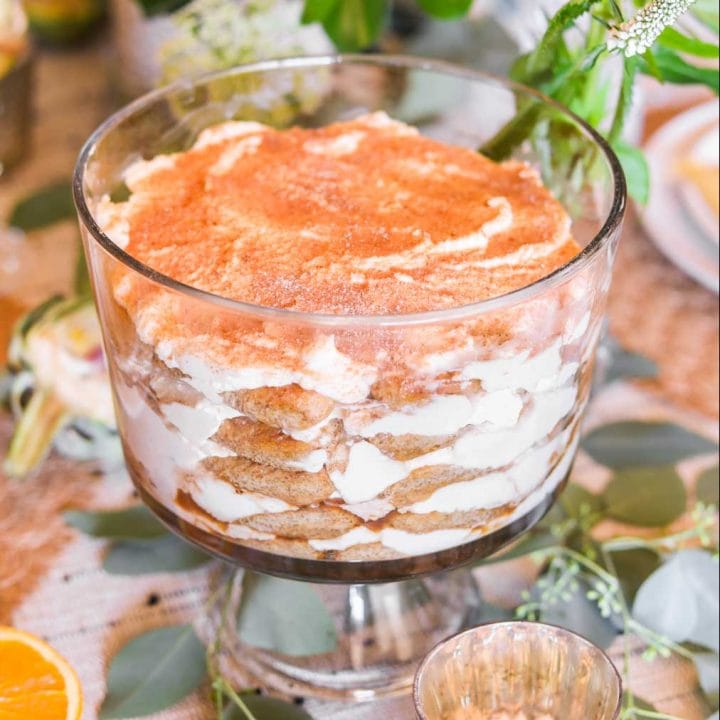 Tiramisu in a glass trifle bowl with green and white flowers