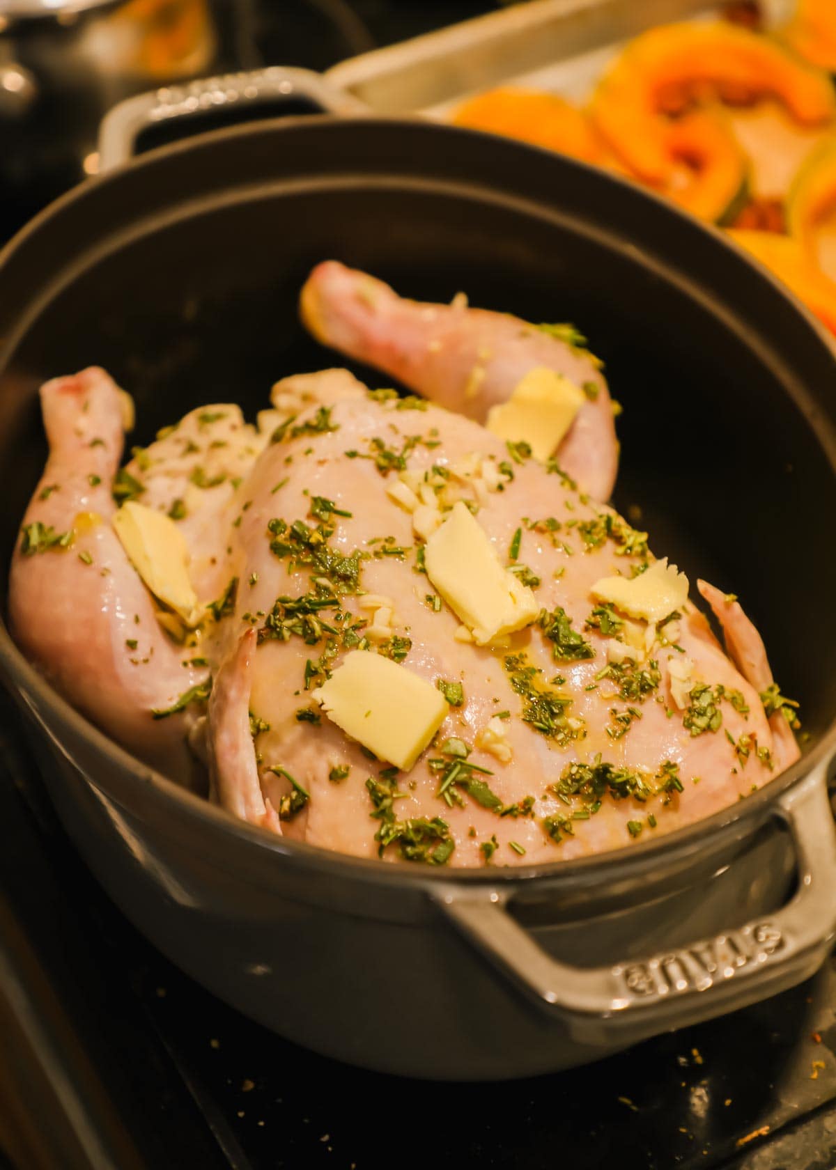 Whole roast chicken in dutch oven brushed with emon juice, butter, chopped sage, rosemary, thyme, kosher salt, and cracked pepper.