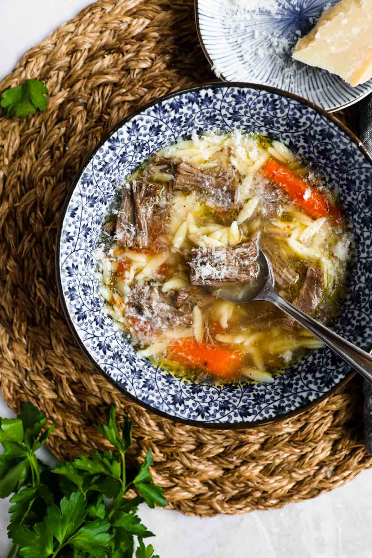 Italian beef soup (brodo di carne) in blue and white bowl.