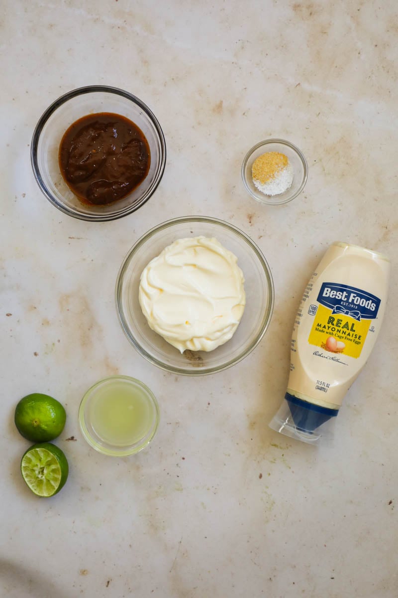 Chipotle mayo ingredients, including lime, mayonnaise, garlic powder, and chipotle peppers in adobo sauce.