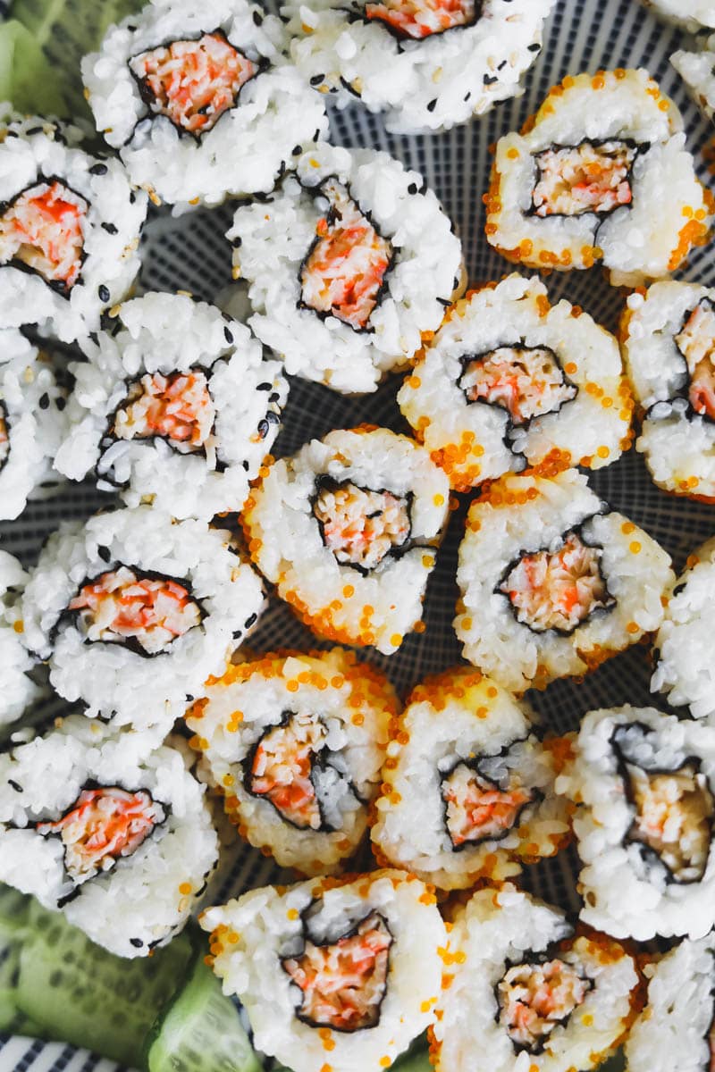 Closeup shot of spicy kani rolls with imitation crab, tobiko, rice, and sesame seeds.