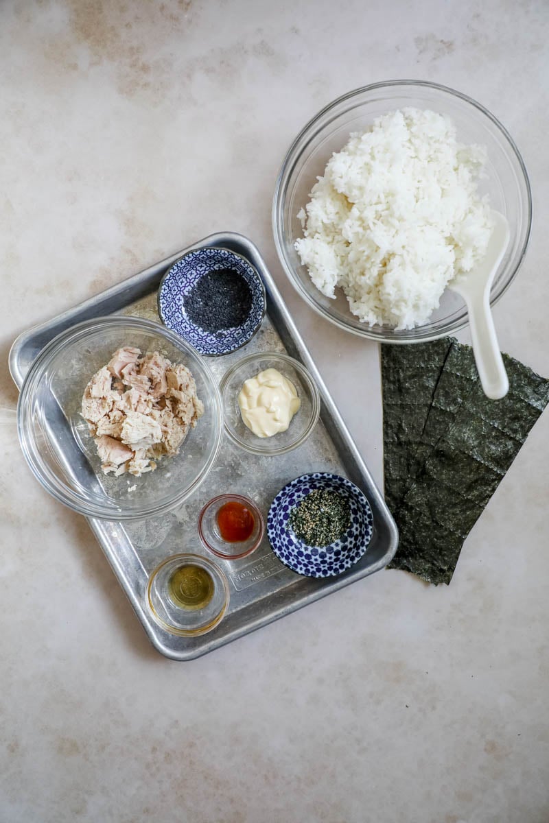 Ingredients to make spicy tuna Onigiri on a sheet pan.