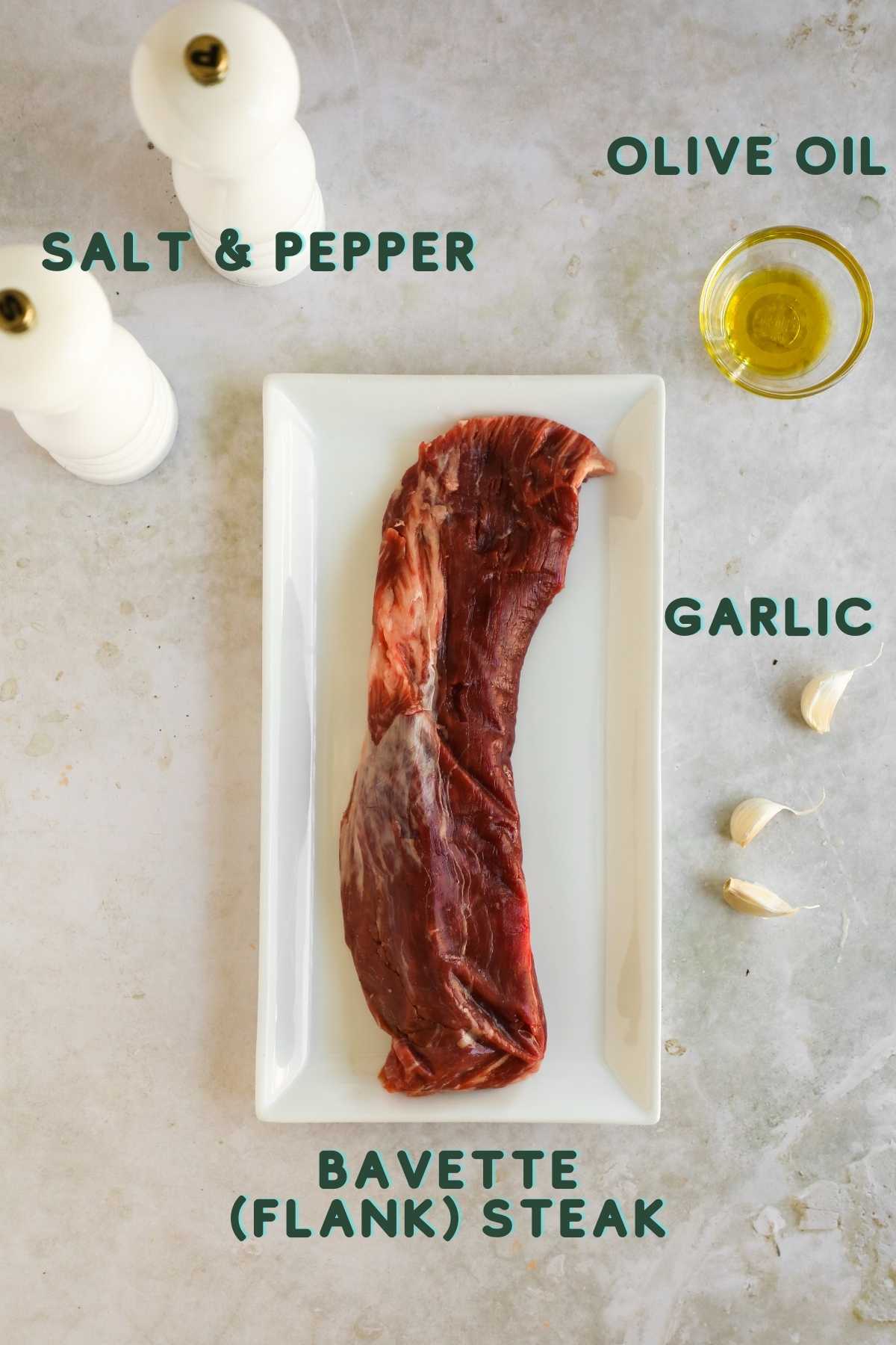 Ingredients to make bavette (flank) steak, including flank steak, garlic, olive oil, salt, and pepper.