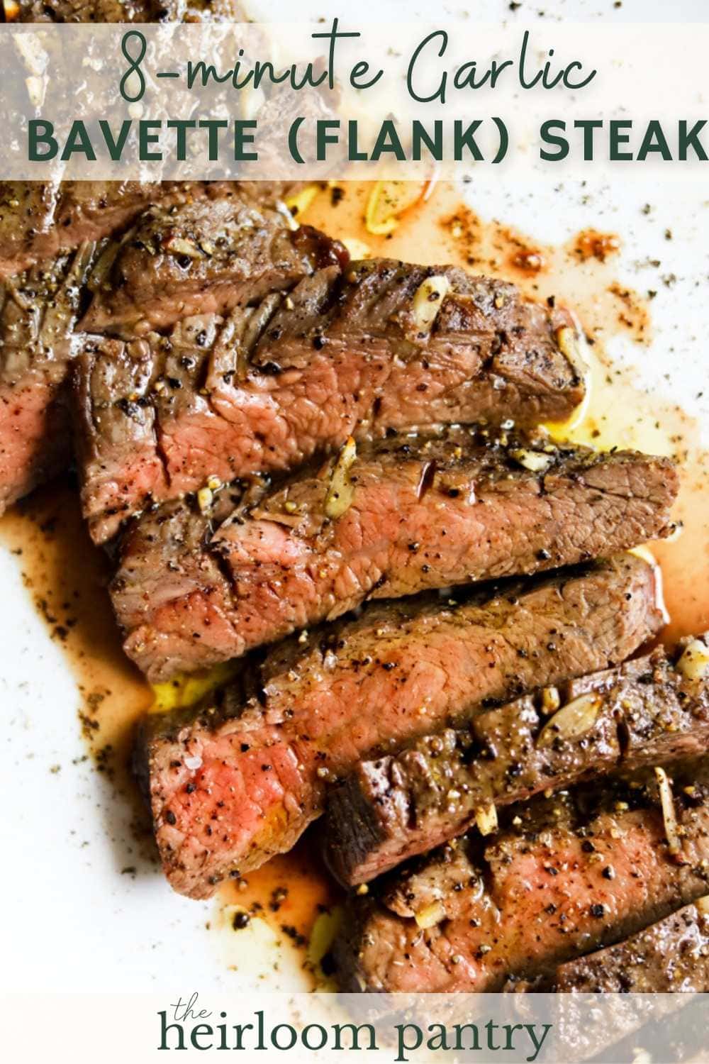 Closeup of bavette steak (garlic flank steak) sliced medium rare on a white plate au jus for Pinterest pin.