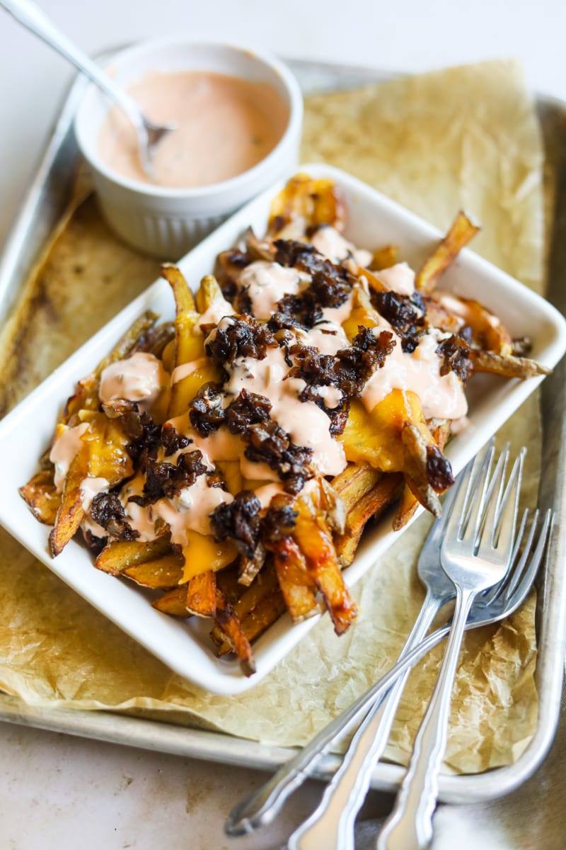In-n-Out animal-style fries copycat recipe in a bowl with forks and secret sauce.