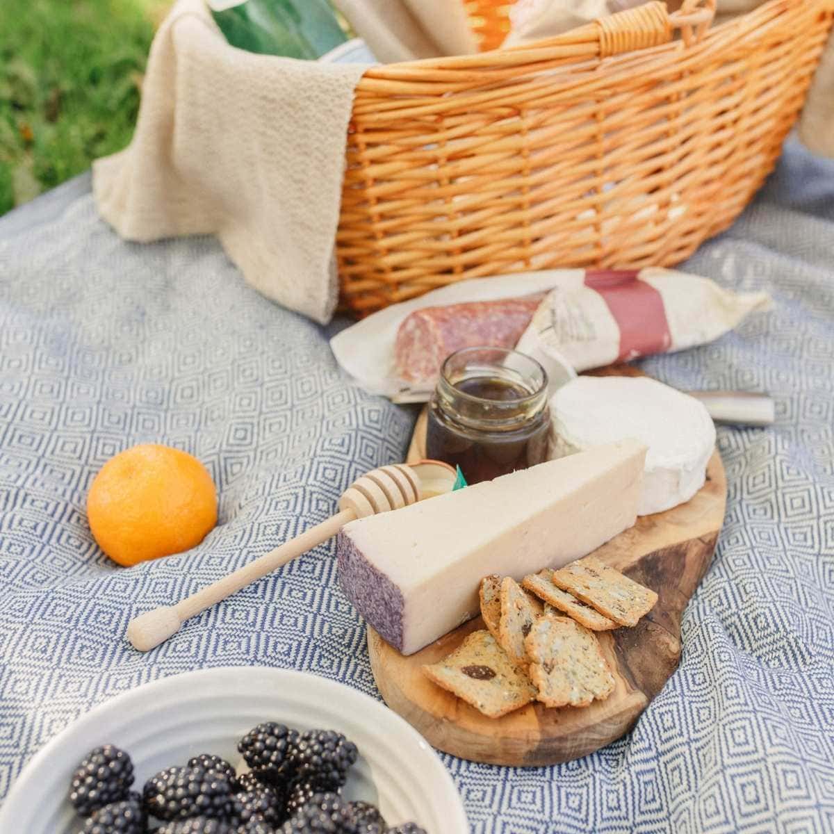 Picnic with Trader Joe's cheese, honey, salami, fruit, and a picnic basket.
