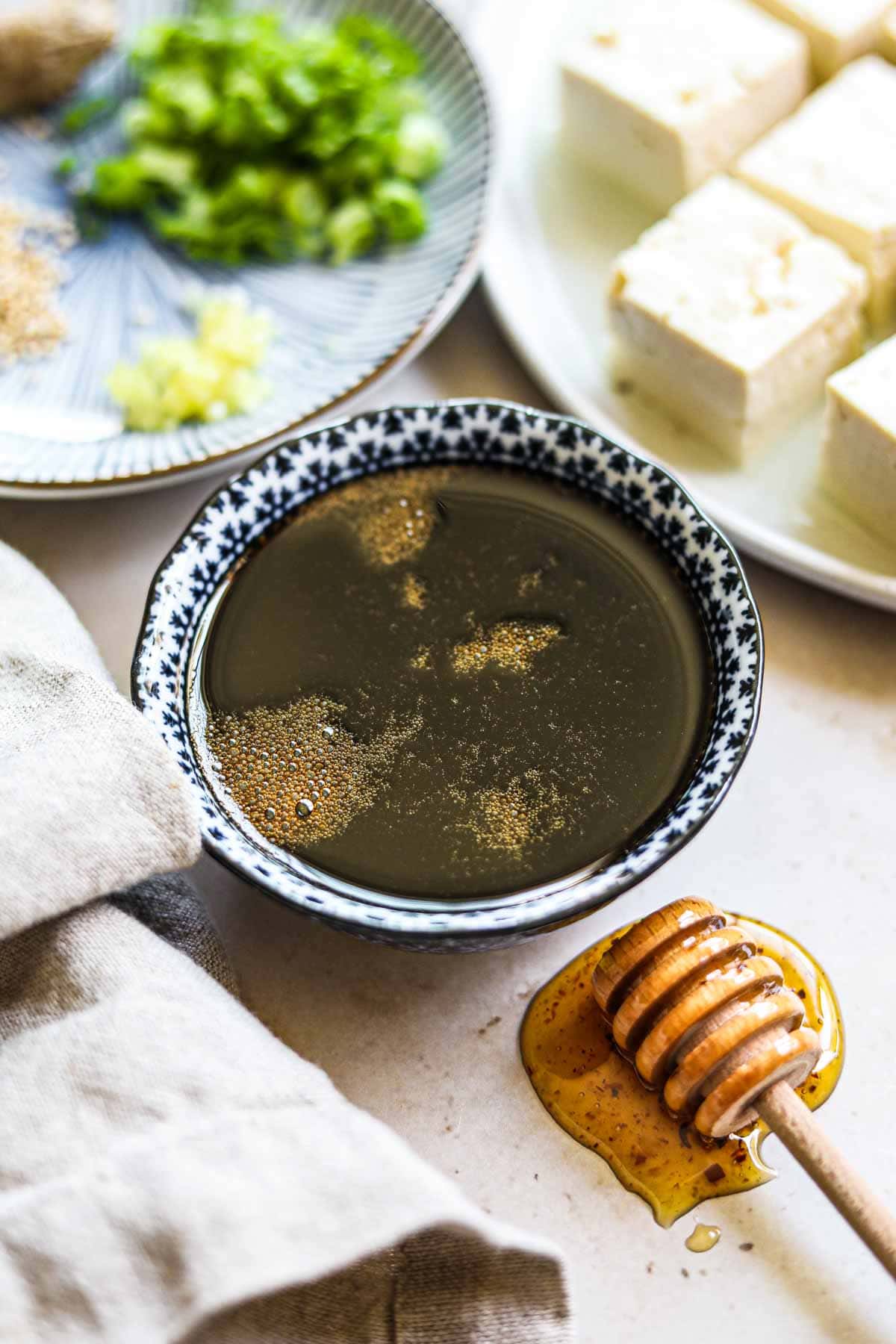 Healthy honey gluten-free teriyaki sauce in a small bowl with a honey dipper.