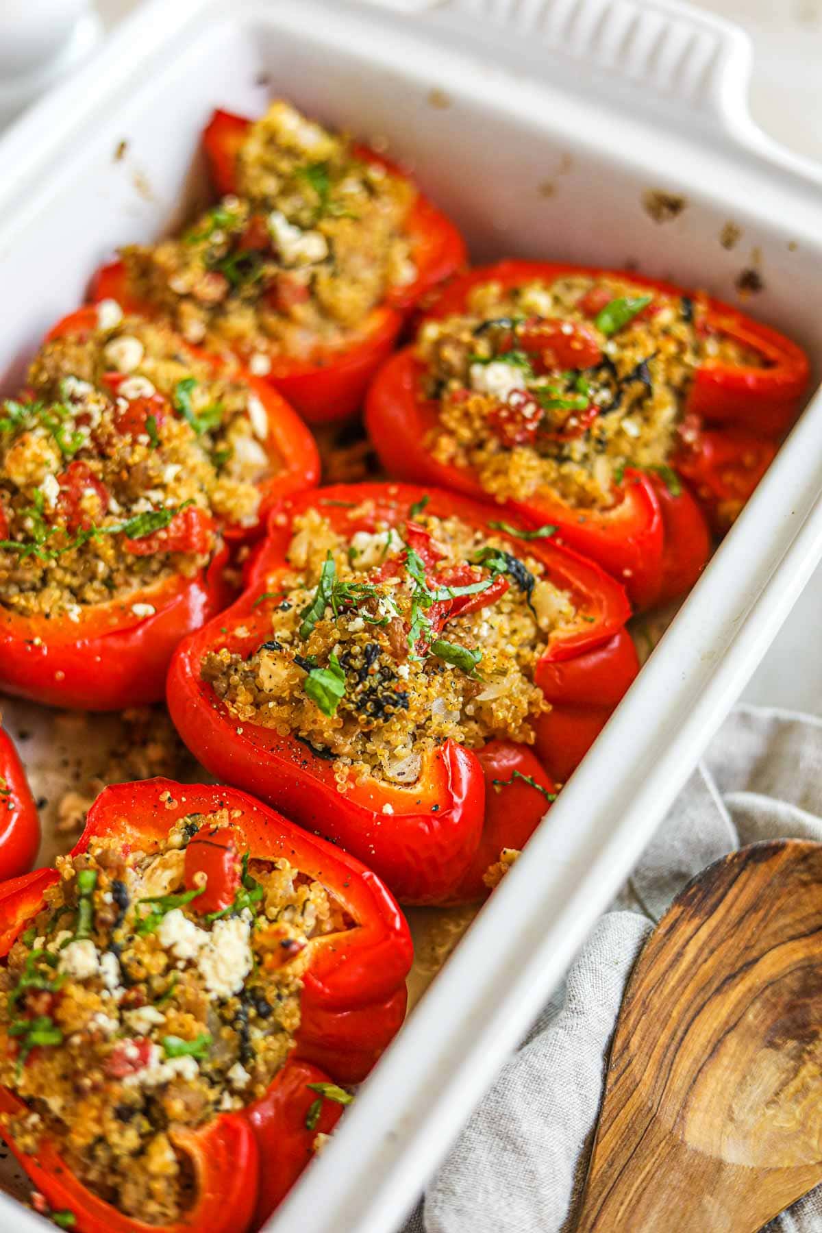 Baked quinoa and turkey stuffed peppers without rice in a Le Creuset baking dish.