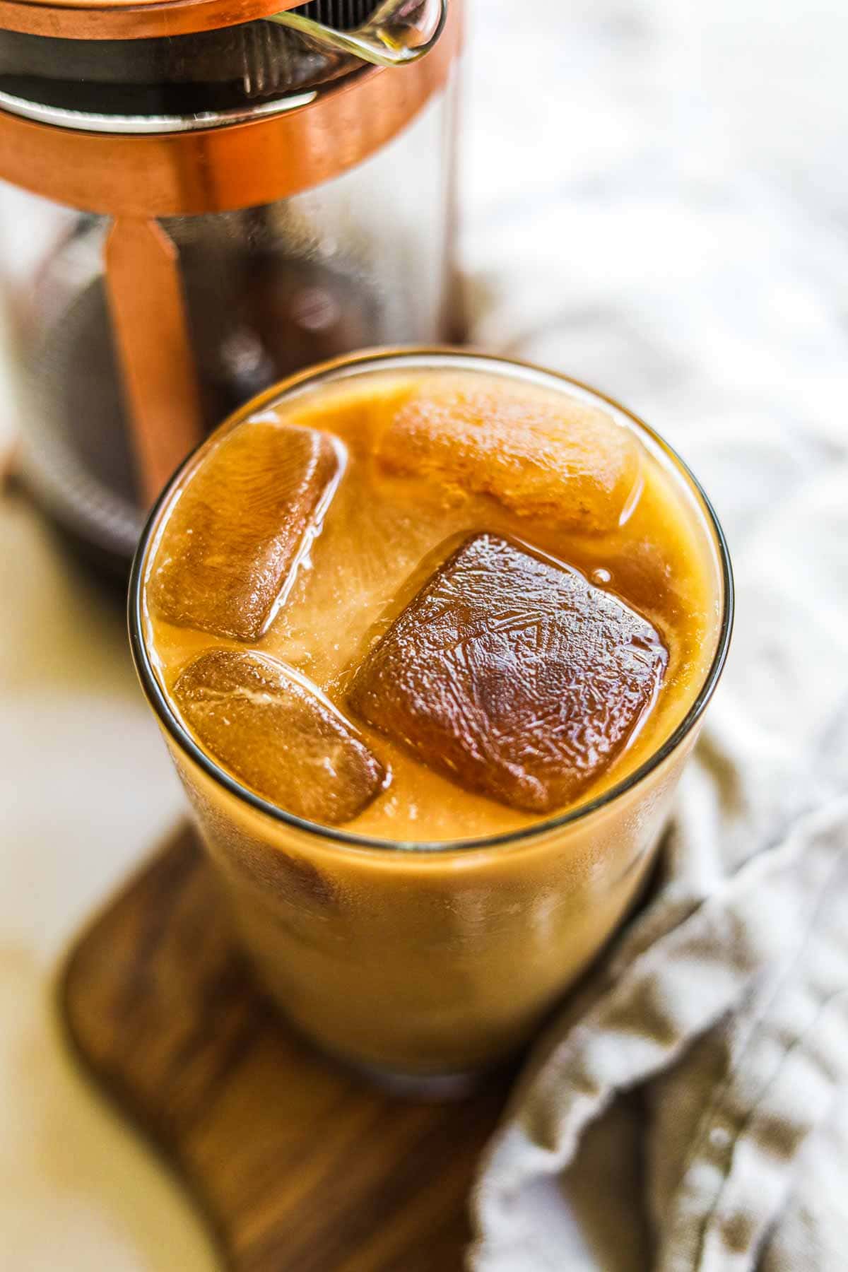 A glass of iced coffee served with coffee ice cubes.