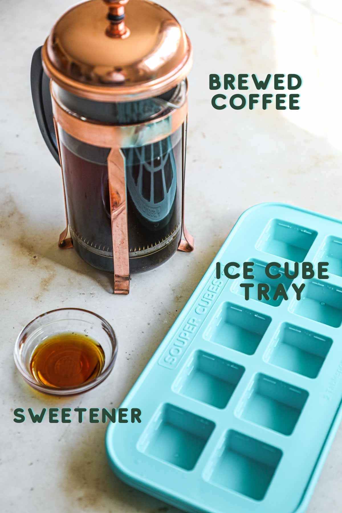 Ingredients to make coffee ice cubes, including brewed coffee, sweetener, and an ice cube tray.