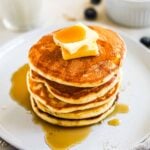 Fluffy dairy-free oat milk pancakes in a stack served with butter and maple syrup.