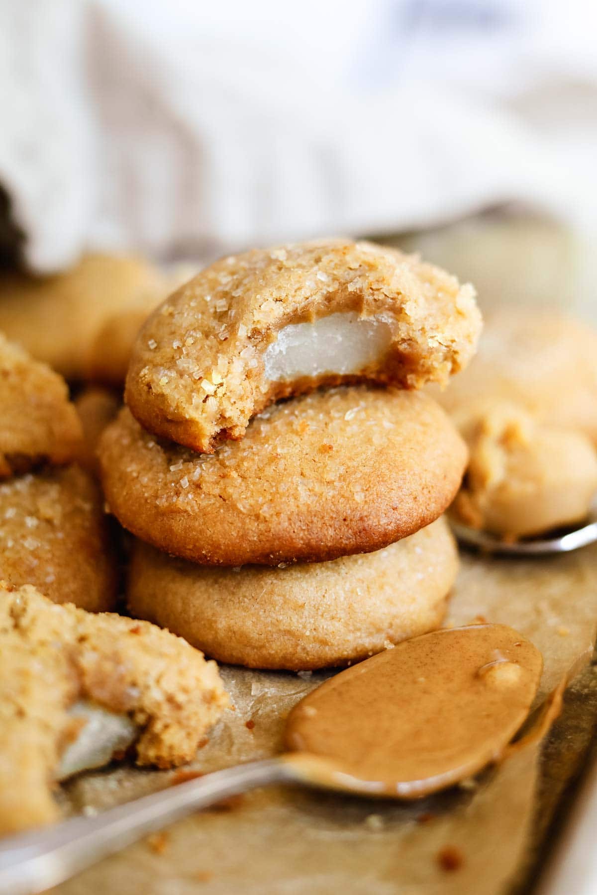 Mochi-stuffed peanut butter and miso cookies stacked with a bite taken out.