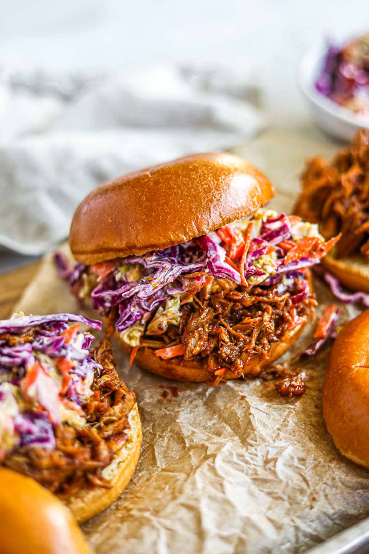 Slow cooker BBQ pulled chicken burgers (sandwiches and sliders) with homemade cabbage coleslaw.