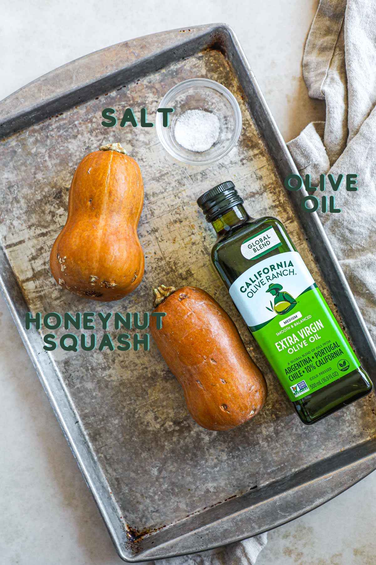 Ingredients to make honeynut squash, including honeynut squash, olive oil, and salt.