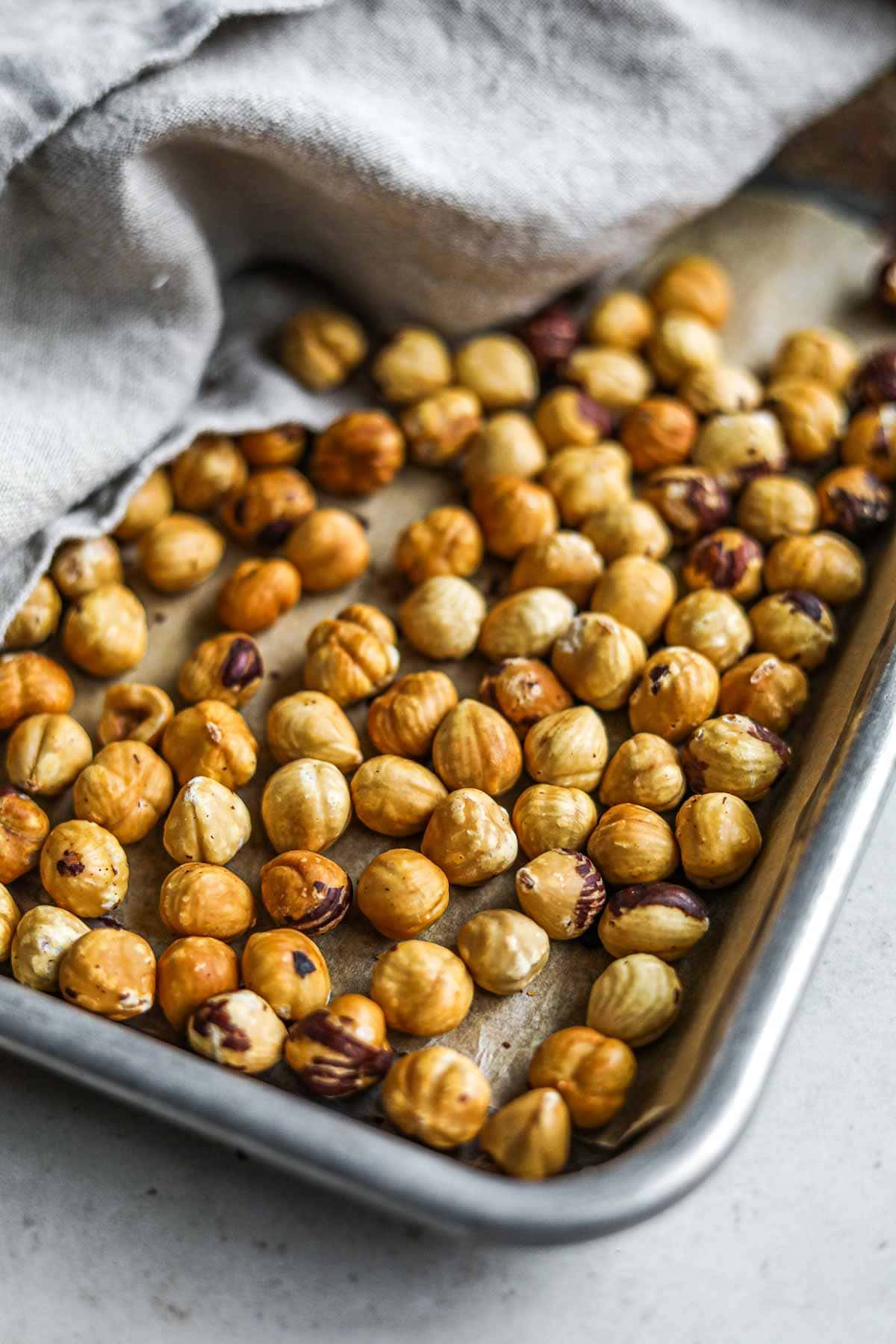 Roasted hazelnuts without the skin on a sheet pan.