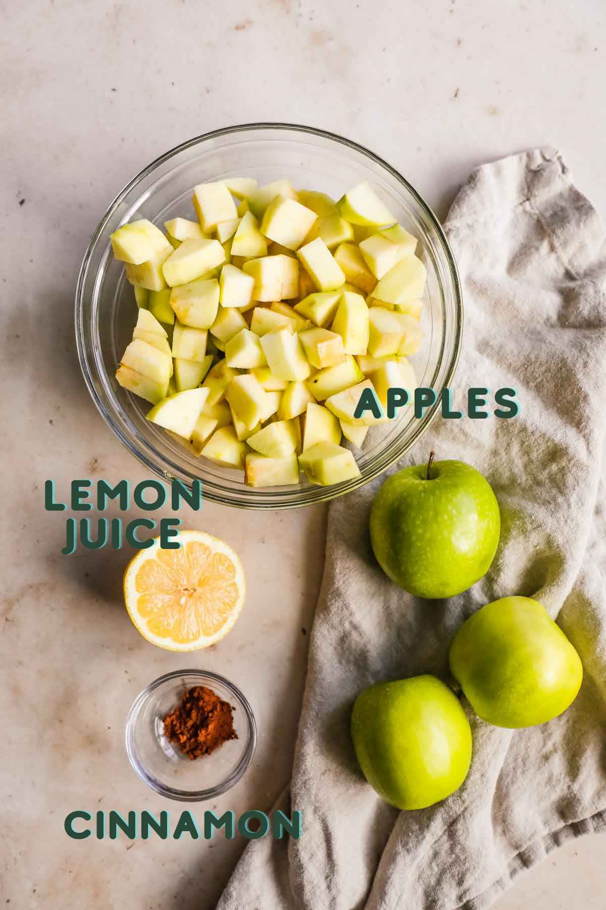 Ingredients to make unsweetened apple sauce, including apples, lemon juice, cinnamon, and water.