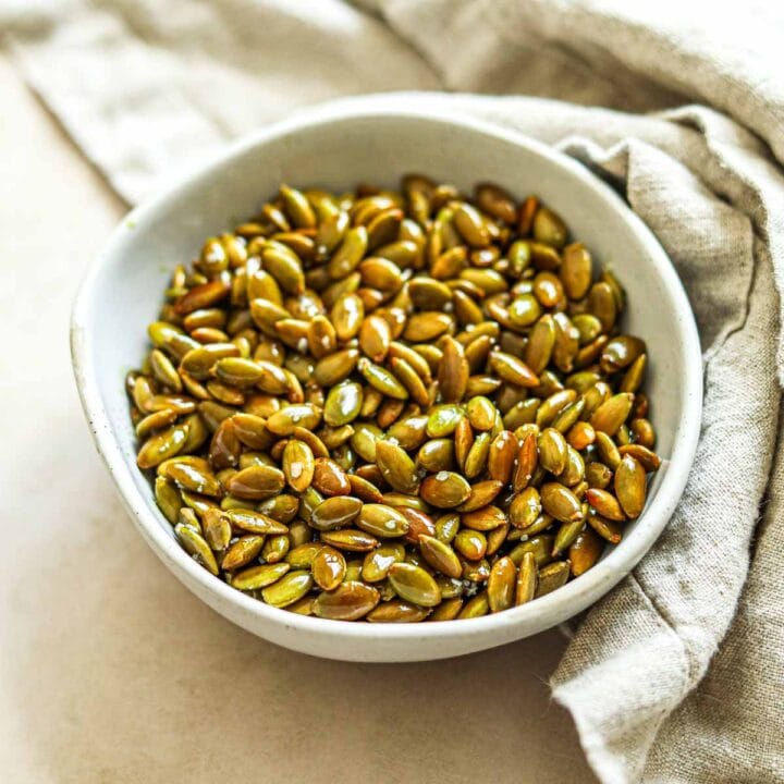 Roasted pumpkin seeds with olive oil and salt in a bowl.