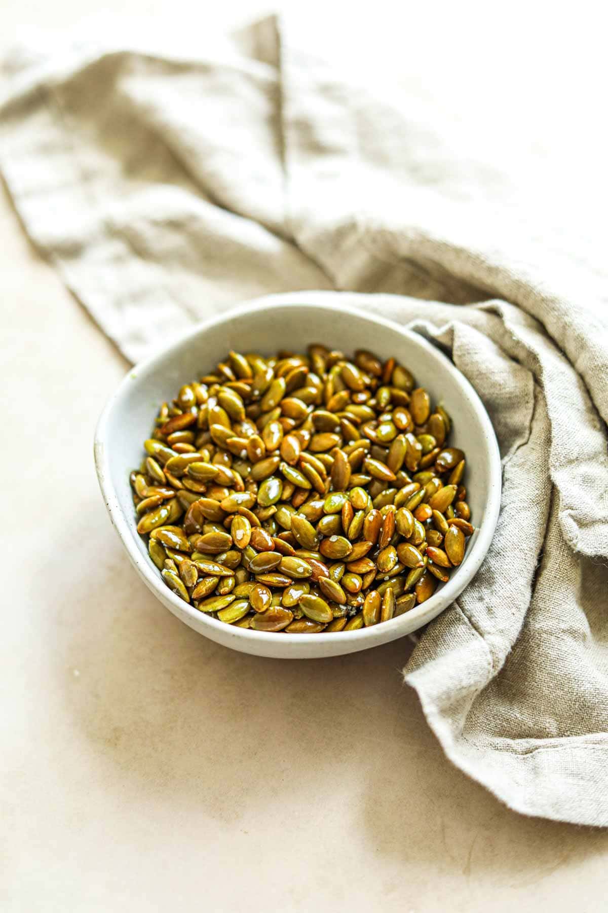 Roasted pumpkin seeds with olive oil and salt in a bowl.