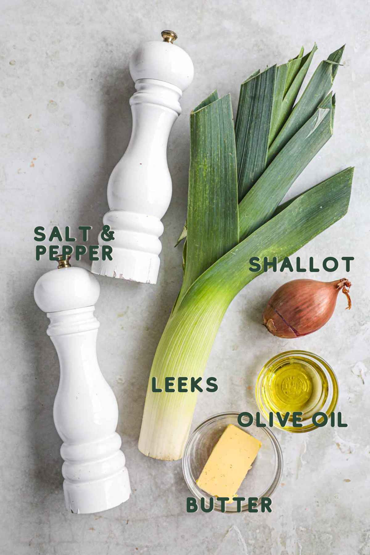 Ingredients to make sautéed buttered leeks and shallots, including leeks, shallot, olive oil, butter, salt, and pepper.