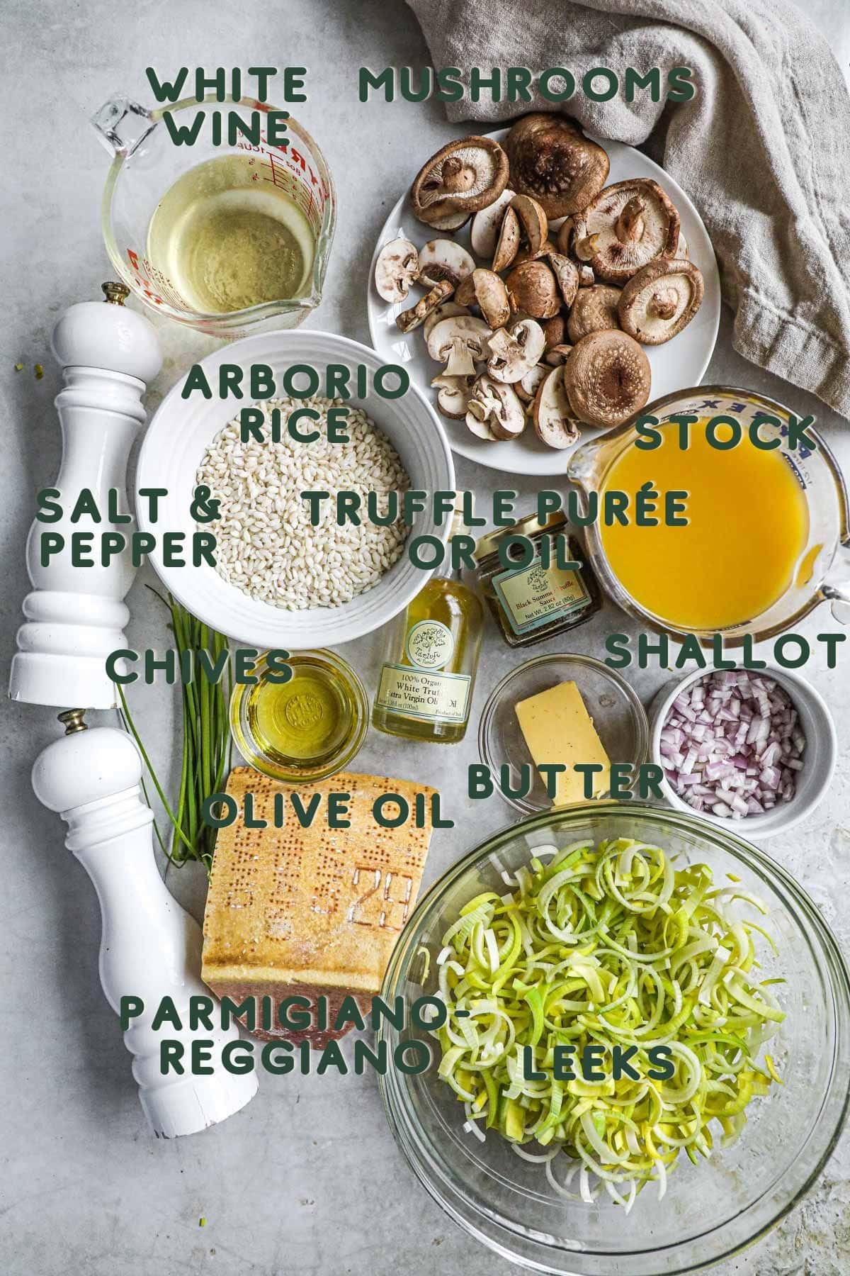Ingredients to make truffle mushroom leek risotto, including leeks, shallots, truffle purée and oil, arborio rice, mushrooms (crimini and shiitake), chicken or vegetable stock, and white wine.