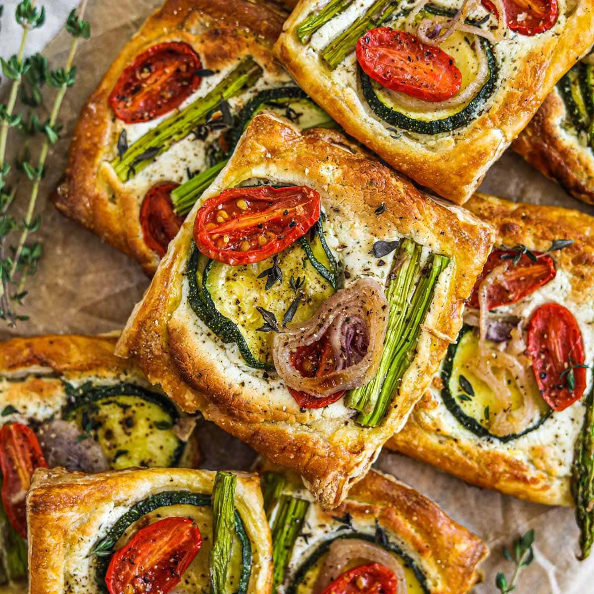 Puff pastry vegetable tarts with herbed goat cheese, cherry tomatoes, asparagus, shallots, and zucchini.