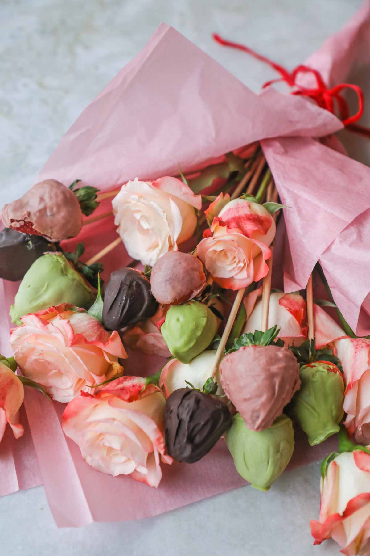 Chocolate dipped strawberry bouquet made with roses, matcha white chocolate strawberries, pink ruby chocolate strawberries, and classic chocolate strawberries.