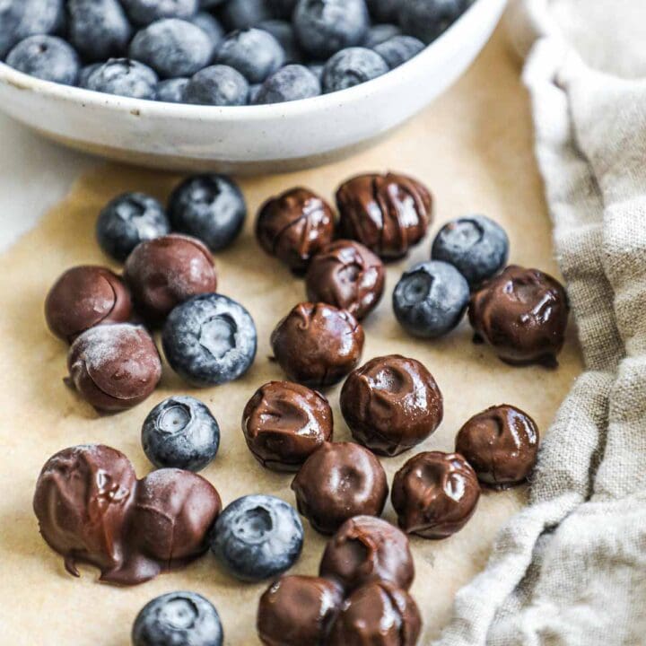 Easy chocolate covered blueberries on parchment paper.