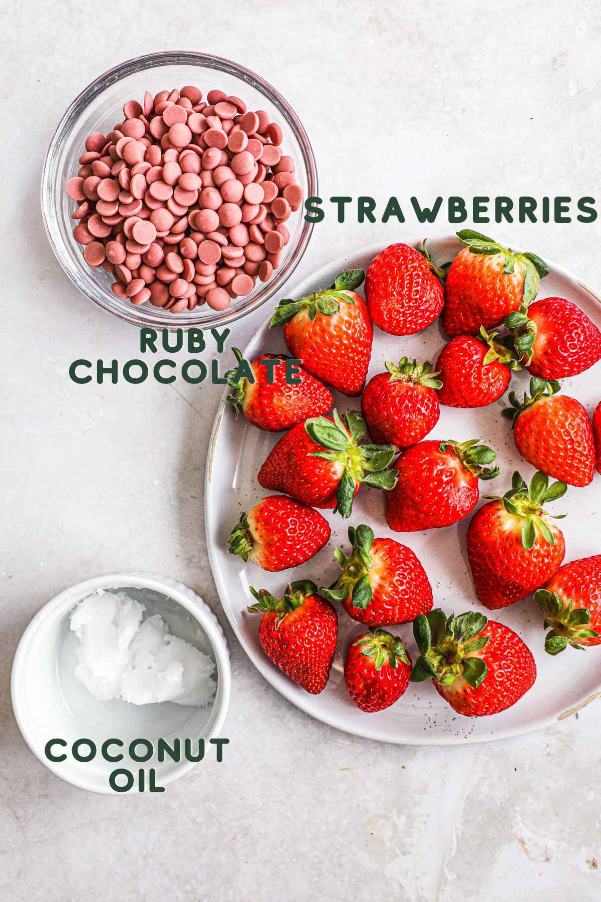 Ingredients to make pink ruby chocolate dipped strawberries, including strawberries, ruby chocolate, and coconut oil.