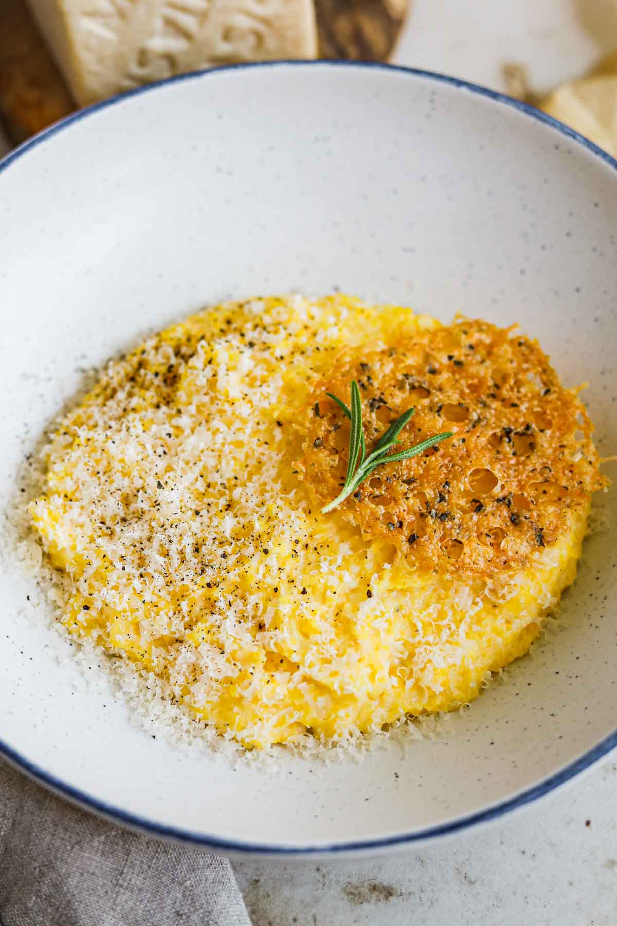 Velvety, smooth Italian parmesan polenta with grated parmigiano-reggiano, rosemary, and a montasio PDO frico (cheese crisp).
