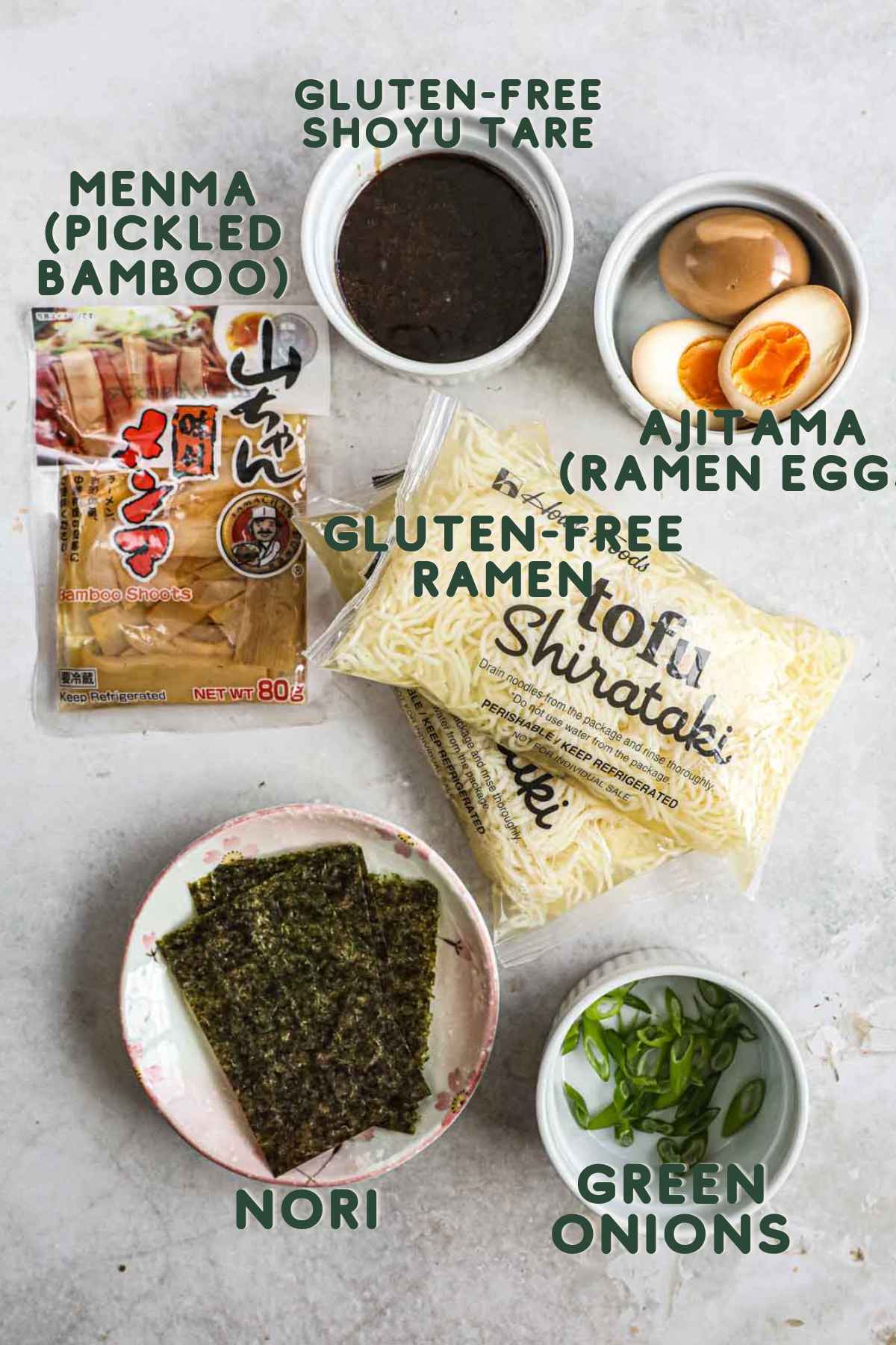 Ingredients to make gluten-free tofu shirataki ramen, including shoyu tare, menma, gluten-free ramen noodles, ajitama, green onions, nori, and miso chicken thighs.