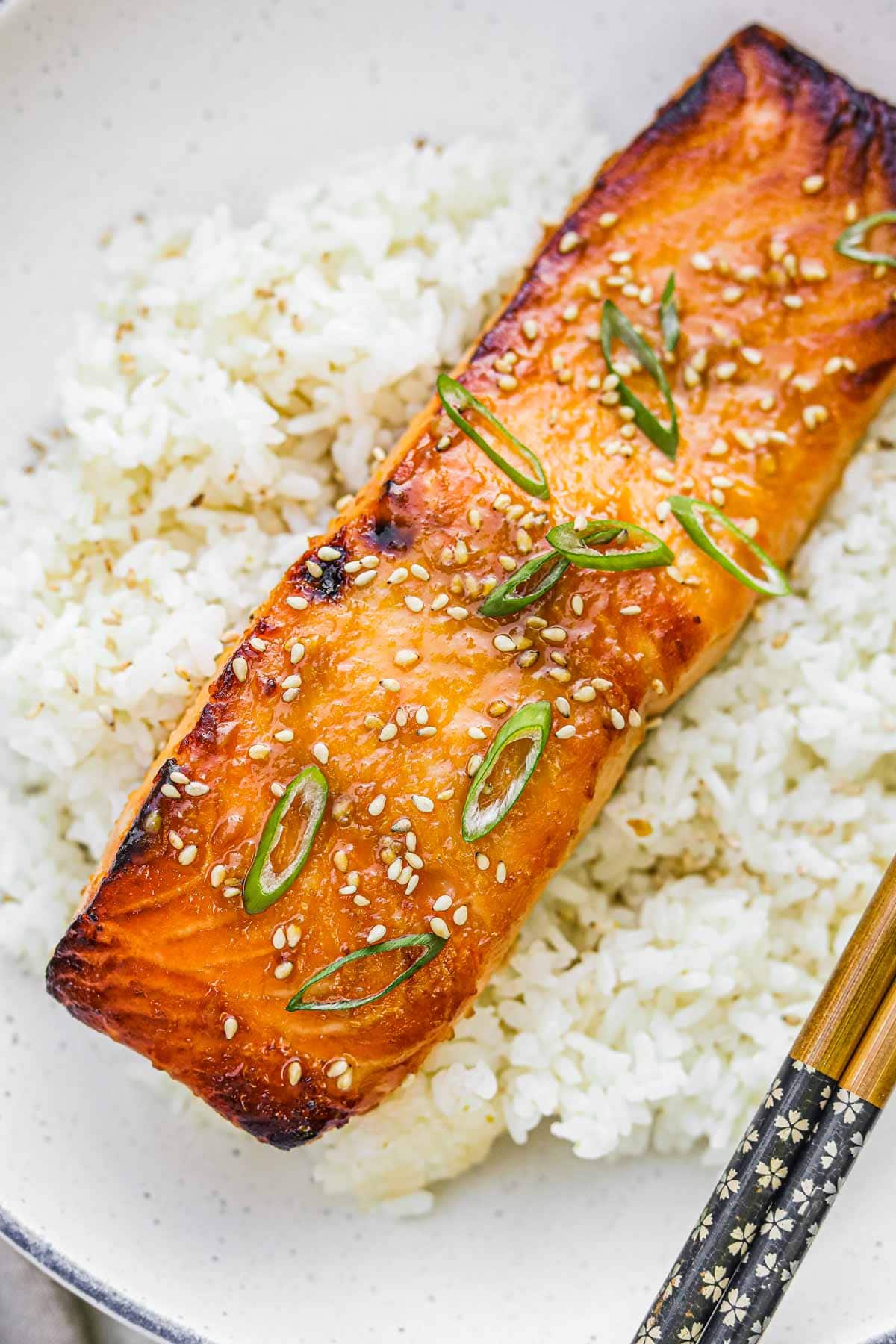 Broiled miso-glazed salmon with charred edges and a medium-rare center on a bed of Japanese rice.