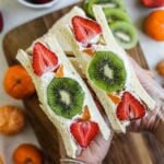 Japanese fruit sandwich (sando) made with shokupan (white bread) and filled with fresh honey whipped cream and fresh fruit, including kiwi, mandarin oranges, and strawberries.
