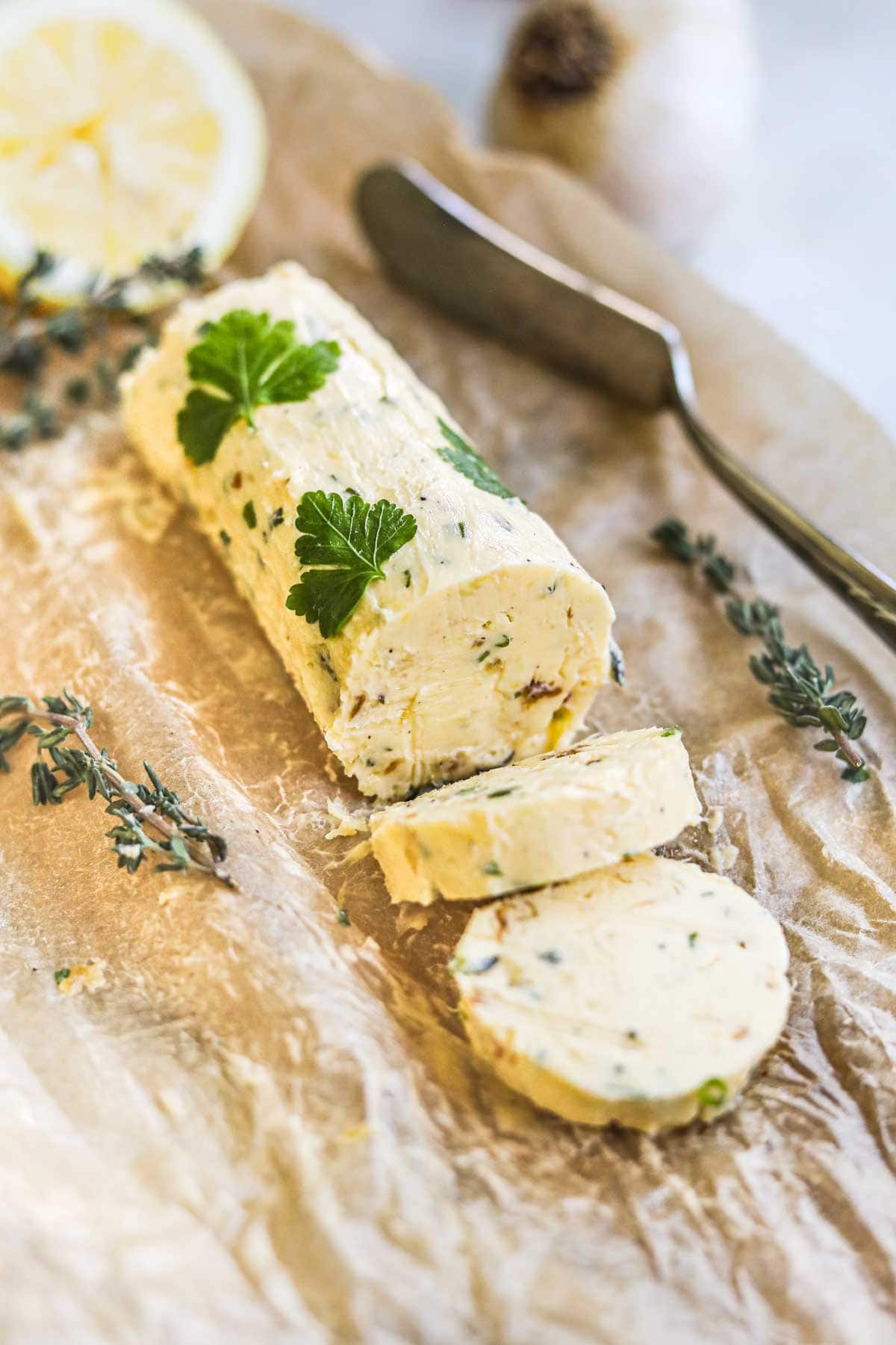 Roasted garlic herb butter with lemon zest and pressed herbs rolled into a log with parchment paper and used for steak, chicken, veggies, and more.
