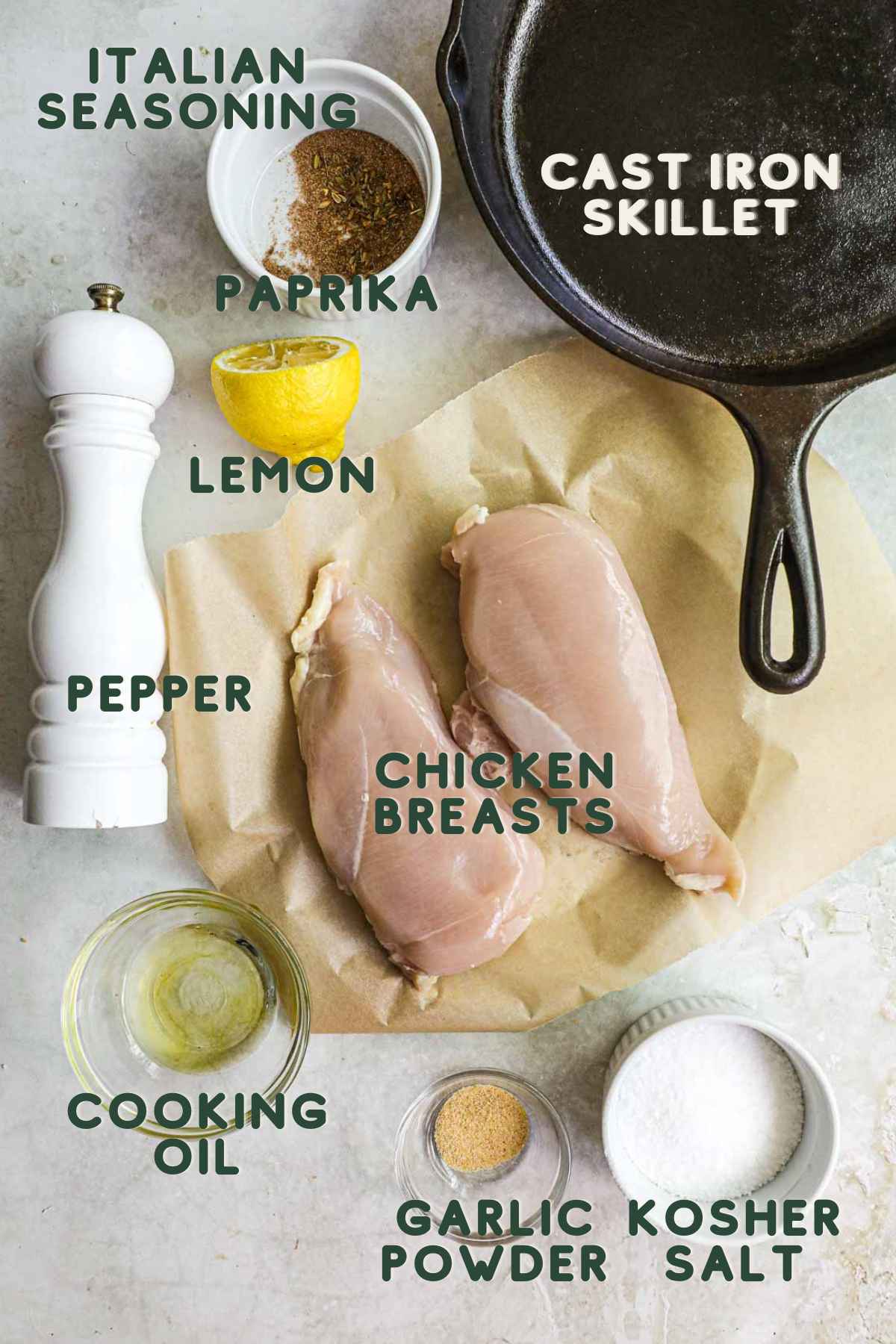 Ingredients to make cast iron chicken breast, chicken breasts, garlic powder, kosher salt, pepper, cooking oil, lemon, paprika, Italian seasoning.