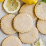 Lemon shortbread cookies with lemon vanilla bean glaze with bits of lemon zest and sliced lemons.