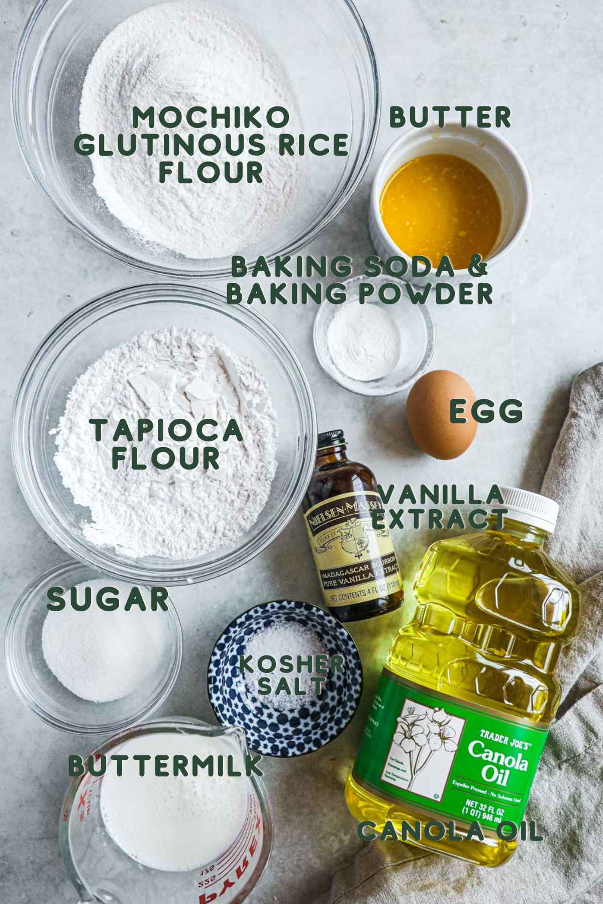 Ingredients to make gluten-free mochi donuts, mochiko, butter, tapioca flour, butter, baking soda and powder, vanilla, egg, sugar, kosher salt, buttermilk, and oil.