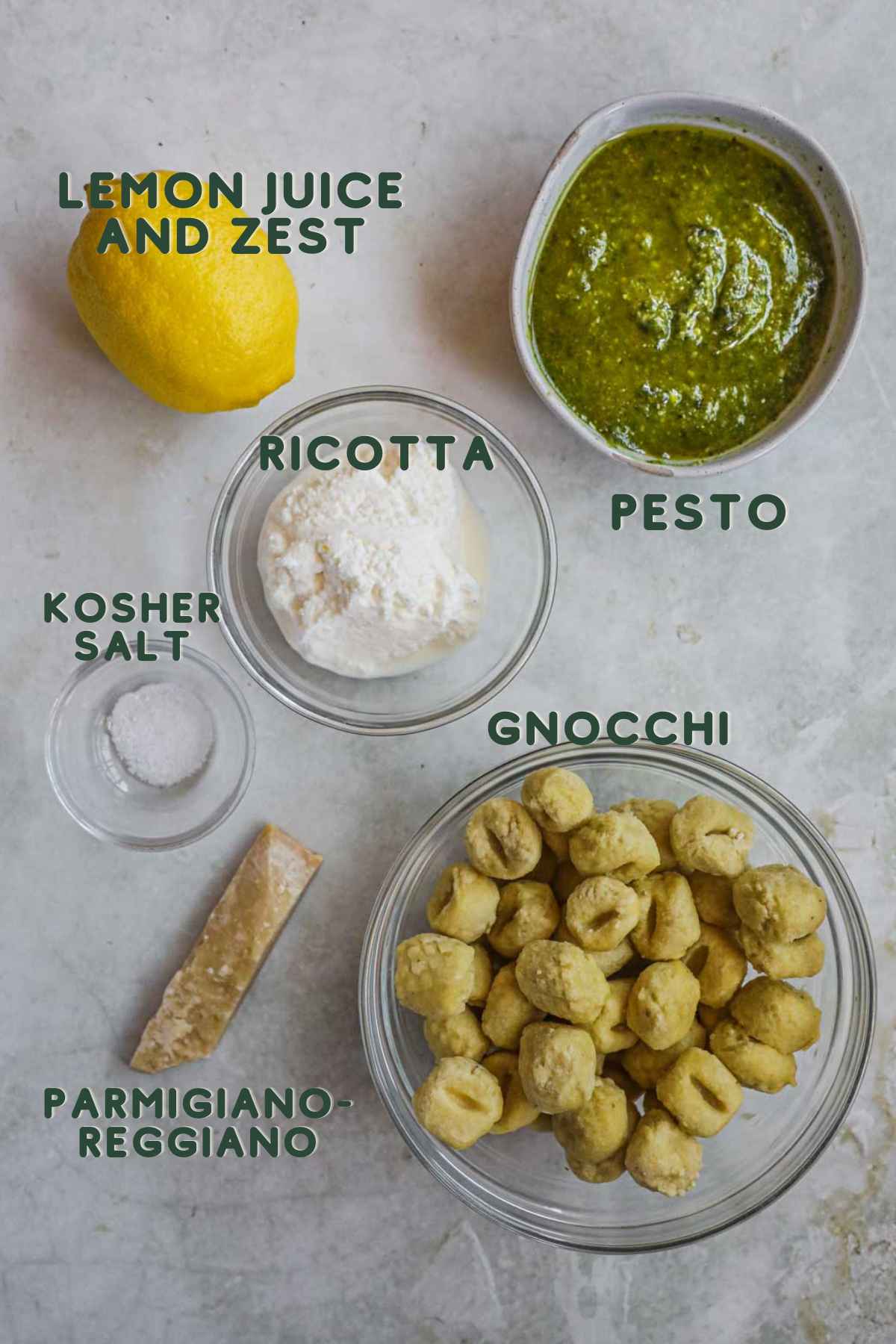 Ingredients to make gnocchi al pesto (creamy pesto gnocchi), gnocchi, pesto, ricotta, kosher salt, parmigiano-reggiano, lemon juice and zest.
