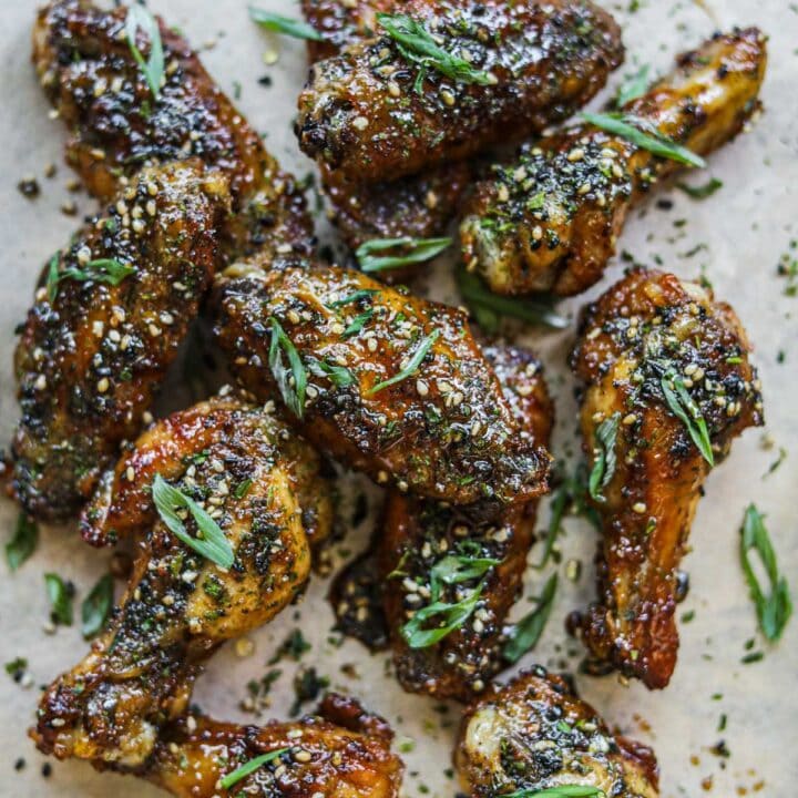 Furikake teriyaki party chicken wings on a serving tray covered in furikake and sliced green onions.
