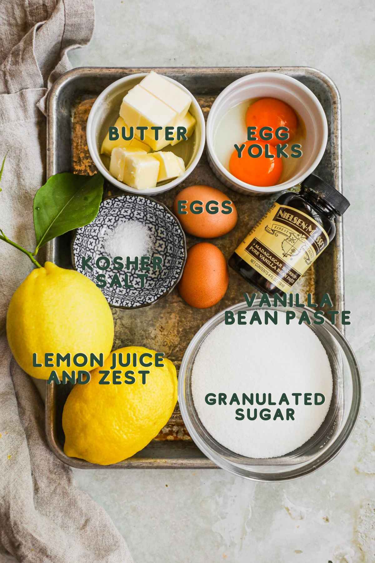 Ingredients for homemade lemon curd, granulated sugar, eggs, yolks, lemon juice and zest, butter, kosher salt, and vanilla bean paste or extract.